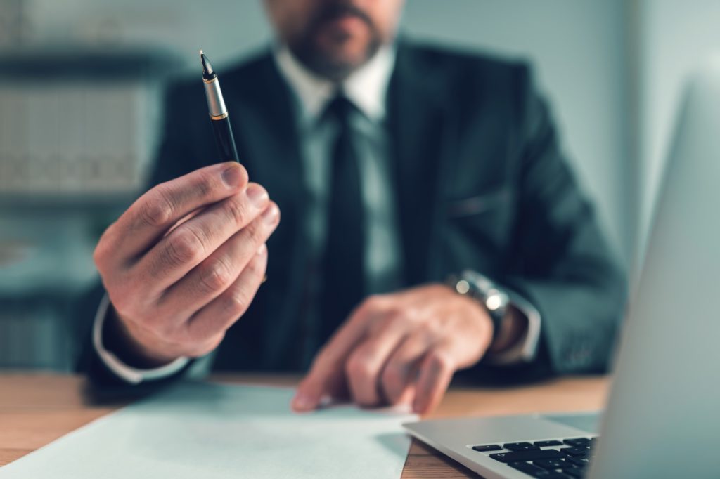 Sign here, bank loan officer offering pen for client to put signature on agreement